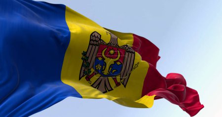 Téléchargez les photos : Drapeau national de Moldavie agitant dans le vent par temps clair. tricolore vertical bleu, jaune et rouge avec les armoiries nationales au centre. Illustration 3D rendu. Tissu flottant - en image libre de droit