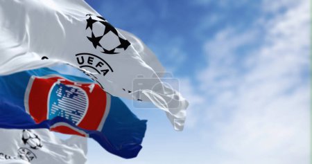 Foto de Londres, Reino Unido, 1 dic 2023: Banderas de la UEFA y la Liga de Campeones de la UEFA ondeando juntas. Competencia europea de fútbol. Tejido ondulado. Ilustrativo editorial 3d illustration render. Enfoque selectivo - Imagen libre de derechos