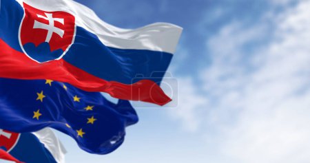 Téléchargez les photos : Gros plan sur la Slovaquie et l'Union européenne drapeaux brandissant dans le vent par temps clair. Illustration 3D rendu. Tissu flottant. Concentration sélective - en image libre de droit
