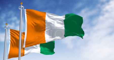 Ivory Coast national flag waving in the wind on a clear day. Three equal vertical stripes: orange, white, and green. 3d illustration render. Fluttering fabric