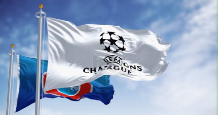 Foto de Londres, Reino Unido, 1 dic 2023: Banderas de la UEFA y la Liga de Campeones de la UEFA ondeando juntas. Competencia europea de fútbol. Tejido ondulado. Ilustrativo editorial 3d illustration render. Enfoque selectivo - Imagen libre de derechos