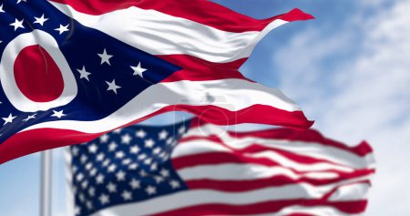 Die Fahne des Staates Ohio weht an einem klaren Tag mit der Nationalflagge der Vereinigten Staaten von Amerika. 3D-Illustrationsrenderer. Wellenförmiges Textil. Selektiver Fokus