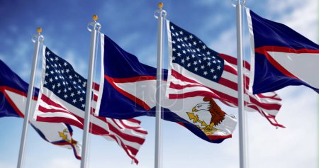 Die Flaggen Amerikanisch-Samoas wehen an einem klaren Tag mit amerikanischen Flaggen. Nicht vereinigtes Territorium der Vereinigten Staaten. 3D Illustration rendern. Selektiver Fokus
