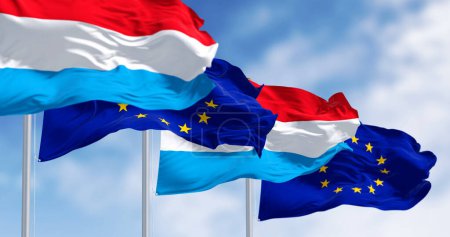 Flaggen Luxemburgs und der Europäischen Union wehen an einem klaren Tag im Wind. Luxemburg wurde im Januar 1958 Mitglied der EU. 3D Illustration rendern. Flatterndes Textil