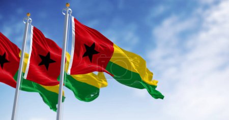 Banderas nacionales de Guinea-Bissau ondeando en el viento en un día claro. Franja roja vertical, estrella negra izquierda, franjas horizontales amarillas y verdes derecha. 3d render ilustración. Tejido de aleteo