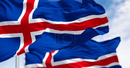 Close-up of two Iceland national flags waving. Blue with a white cross and a red cross inside the white cross. 3d illustration render. Fluttering fabric. Selective focus