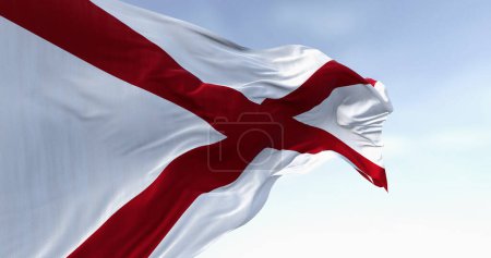 Gros plan du drapeau de l'État de l'Alabama agitant un jour ensoleillé. Le drapeau de l'Alabama comporte une croix rouge sur un champ blanc. Illustration 3D rendu, Tissu flottant.