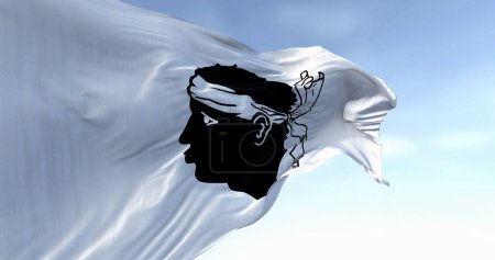 Flag of Corsica waving in the wind on a clear day. Black Moor's head with a white bandana on a white field. French region. 3d illustration render. Selective focus