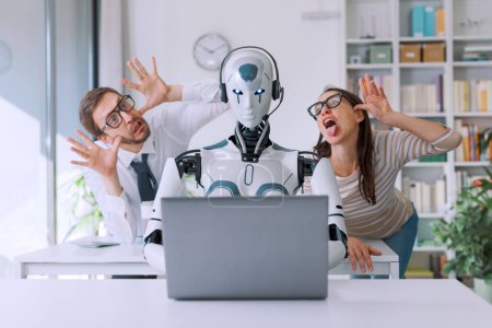 Foto de Gente de negocios burlándose de su colega robot AI sentado en el escritorio y trabajando - Imagen libre de derechos