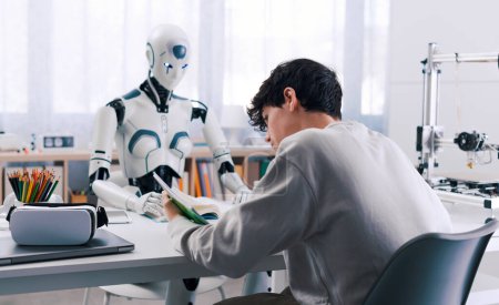 Ein Junge studiert mit Hilfe eines Roboters. Das Ergebnis ist fruchtbar. Konzept der Zusammenarbeit zwischen Robotern und Menschen.