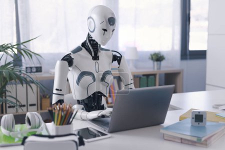 Foto de Un robot humanoide trabaja en una oficina en un ordenador portátil, mostrando la utilidad de la automatización en tareas repetitivas y tediosas. - Imagen libre de derechos