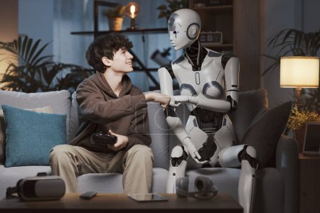 Téléchargez les photos : Souriant garçon et robot AI jouer à des jeux vidéo ensemble à la maison ils sont amis et donnant une bosse poing - en image libre de droit