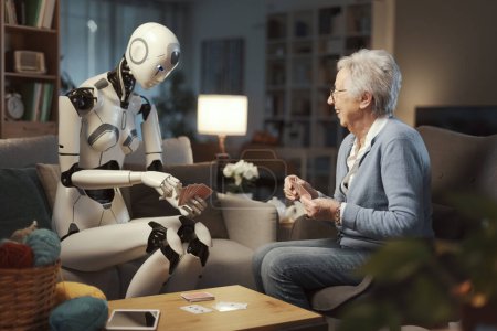 Téléchargez les photos : Une dame âgée passe un après-midi amusant à cioing cartes avec son robot avec I.A. Elle est sûre qu'il ne trichera pas.. - en image libre de droit