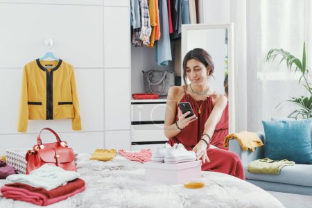Fashionable woman decluttering her wardrobe, she is selling her used clothes and accessories online