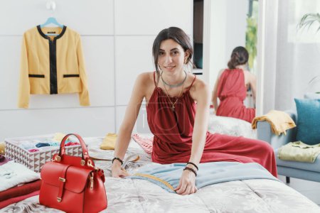 Foto de Mujer midiendo pantalones tamaño de cintura en el dormitorio usando una cinta métrica - Imagen libre de derechos
