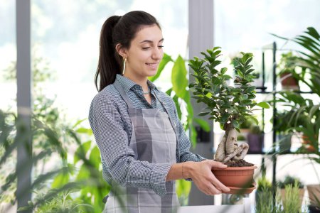 Photo for Professional young florist taking care of plants in the garden center, gardening and plants concept - Royalty Free Image