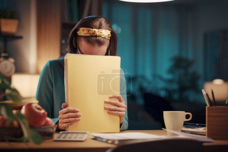 Foto de Mujer frustrada sentada en su escritorio en casa y revisando el papeleo: finanzas del hogar, costos y concepto de presupuesto - Imagen libre de derechos