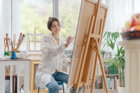 Foto de Joven mujer creativa pintura sobre lienzo en el estudio de arte, arte y concepto de hobby - Imagen libre de derechos