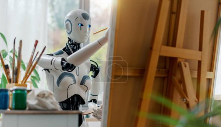 Téléchargez les photos : Robot humanoïde créatif travaillant dans le studio d'art, elle peint sur toile - en image libre de droit