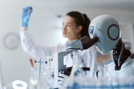 Téléchargez les photos : Femme scientifique et robot IA travaillant ensemble dans le laboratoire scientifique - en image libre de droit