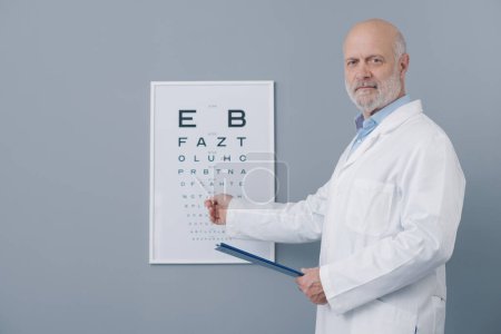 Téléchargez les photos : Ophtalmologiste pointant vers le tableau oculaire, concept de soins oculaires - en image libre de droit