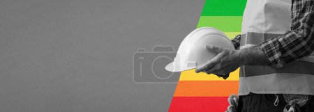 Téléchargez les photos : Travailleur de la construction tenant un casque de sécurité et un indice d'efficacité énergétique du bâtiment, bannière avec espace de copie - en image libre de droit