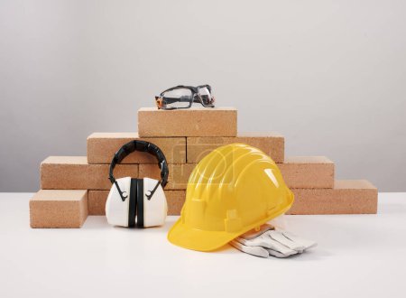 Téléchargez les photos : Sécurité au travail et équipements de protection individuelle pour les travailleurs de la construction : casque de sécurité, cache-oreilles et lunettes - en image libre de droit