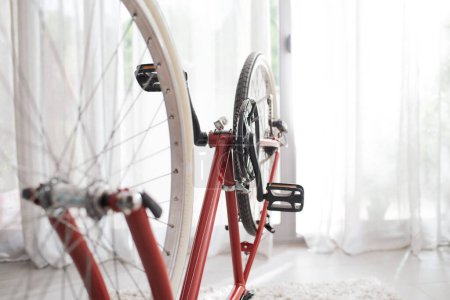 Téléchargez les photos : Sport vélo à l'envers à la maison et fenêtre en arrière-plan, concept de transport durable - en image libre de droit