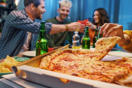 Foto de Grupo de amigos comiendo pizza juntos en casa, comida rápida y concepto de entrega de comida - Imagen libre de derechos