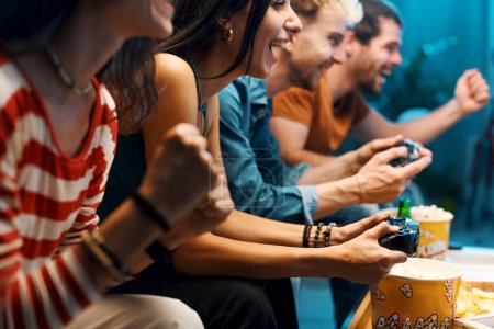 Foto de Alegre grupo de amigos jugando videojuegos juntos en casa, ocio y entretenimiento concepto - Imagen libre de derechos