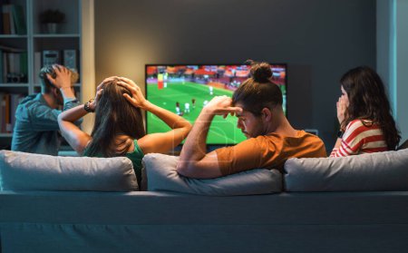 Téléchargez les photos : Triste groupe d'amis déçus de regarder un match de football à la télévision, leur équipe perd le match - en image libre de droit