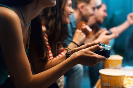 Téléchargez les photos : Groupe joyeux d'amis jouant à des jeux vidéo ensemble à la maison, concept de loisirs et de divertissement - en image libre de droit