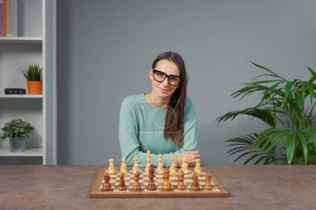 Photo for Woman sitting at desk and teaching chess online, online courses and hobbies concept - Royalty Free Image