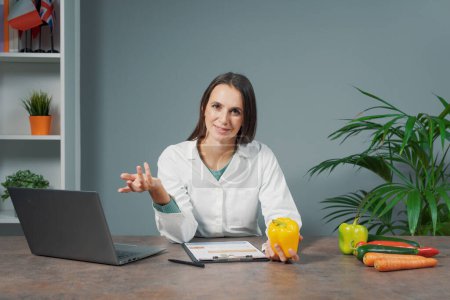 Foto de Nutricionista profesional sentado en el escritorio y dando consejos sobre dieta y alimentación saludable, webinar y concepto de aprendizaje en línea - Imagen libre de derechos