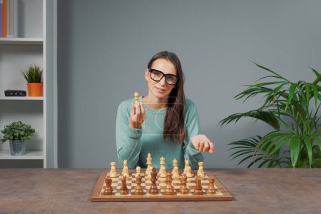 Photo for Woman sitting at desk and teaching chess online, online courses and hobbies concept - Royalty Free Image