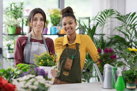 Foto de Jóvenes floristas femeninas trabajando juntas en la florería, la pequeña empresa y el concepto de emprendimiento - Imagen libre de derechos
