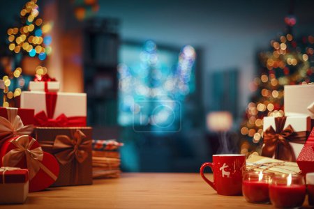 Foto de Hermosos adornos y regalos en una mesa y decorado interior de la casa en el fondo: concepto de Navidad y vacaciones - Imagen libre de derechos