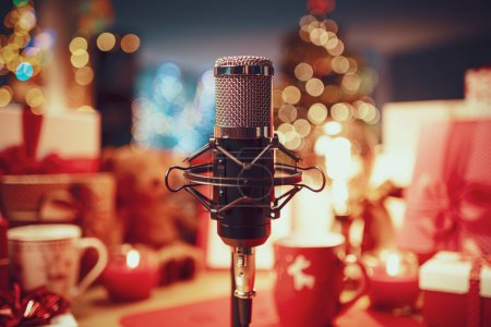 Foto de Decoraciones navideñas, regalos y micrófono profesional en primer plano: concepto de podcast navideño - Imagen libre de derechos