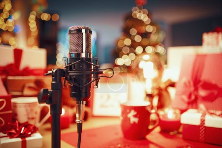 Foto de Decoraciones navideñas, regalos y micrófono profesional en primer plano: concepto de podcast navideño - Imagen libre de derechos