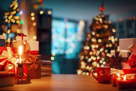 Foto de Regalos y decoraciones en una mesa, árbol de Navidad y el interior del hogar en el fondo, espacio de copia - Imagen libre de derechos