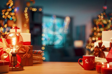 Foto de Hermosos adornos y regalos en una mesa y decorado interior de la casa en el fondo: concepto de Navidad y vacaciones - Imagen libre de derechos