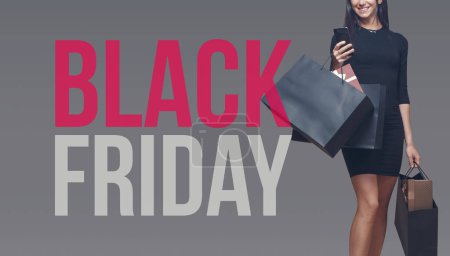 Photo for Happy elegant woman holding shopping bags and a smartphone, Black Friday sale banner - Royalty Free Image