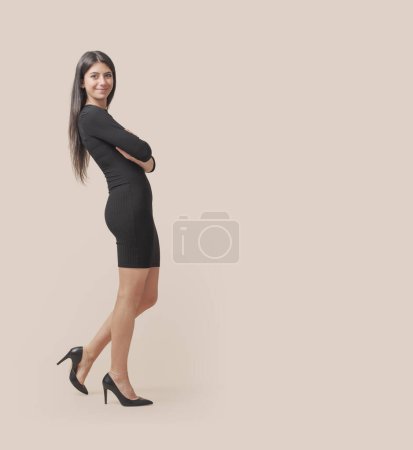 Téléchargez les photos : Belle jeune femme portant une robe noire et posant - en image libre de droit