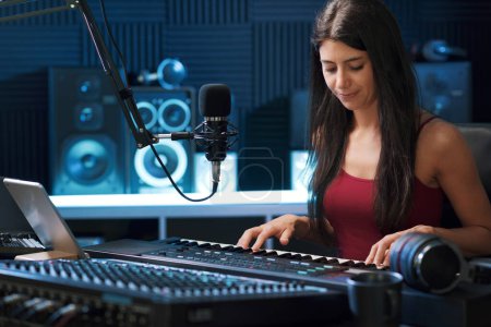 Téléchargez les photos : Jeune musicienne créative travaillant dans le studio d'enregistrement, elle joue du clavier - en image libre de droit