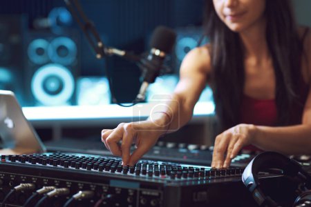 Photo for Young musician setting up the audio mixer in the recording studio, hands close up - Royalty Free Image