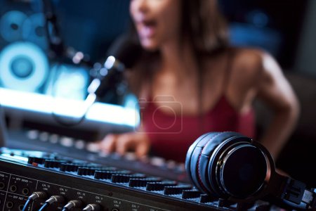 Téléchargez les photos : Enregistrement de musiciens en studio, mixeur audio et écouteurs au premier plan - en image libre de droit