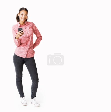 Foto de Mujer joven sonriente de pie y usando un teléfono inteligente - Imagen libre de derechos