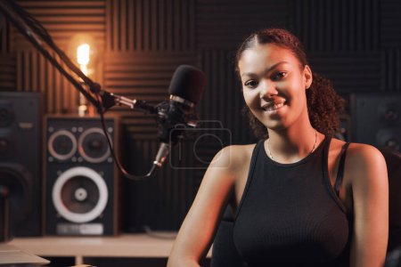 Photo for Young artist posing in the recording studio, she is smiling at camera - Royalty Free Image