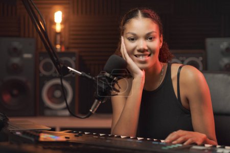 Téléchargez les photos : Jeune artiste heureuse femme dans le studio d'enregistrement, elle sourit à la caméra - en image libre de droit