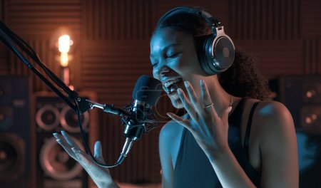 Téléchargez les photos : Jeune femme séduisante travaillant dans le studio d'enregistrement, elle chante dans un microphone - en image libre de droit